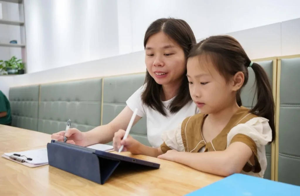 Orang tua mendampingi anak menggunakan gadget untuk belajar